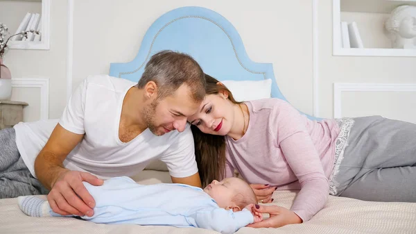 Attrayant homme et femme regardant bébé endormi doux dans la chambre — Photo