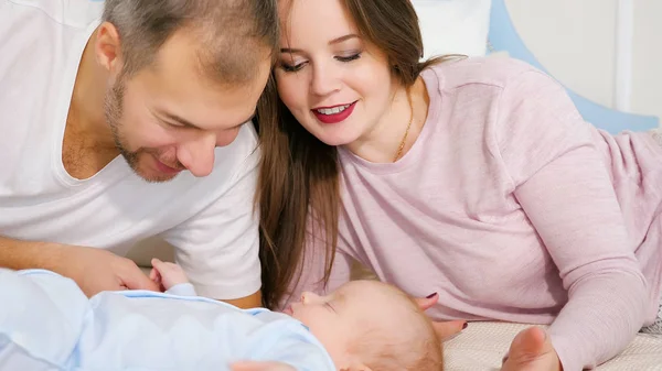 Attrayant homme et femme regardant bébé endormi doux dans la chambre — Photo