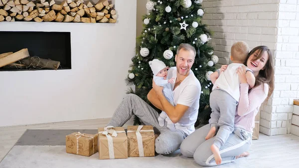 Family having fun near Christmas tree and gifts