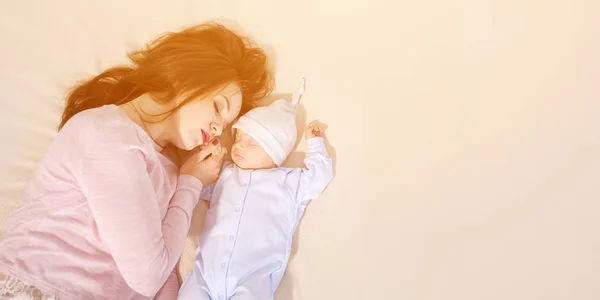 Joven madre durmiendo cerca del bebé — Foto de Stock