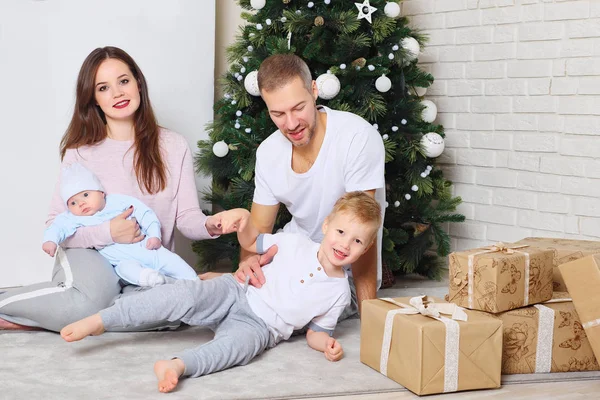 Familia feliz cerca del árbol de Navidad y regalos — Foto de Stock
