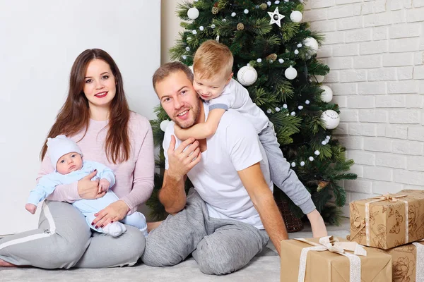 Familia feliz cerca del árbol de Navidad y regalos — Foto de Stock