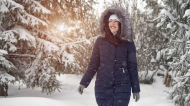 Genç kadın bir güzel kış orman yürüyor