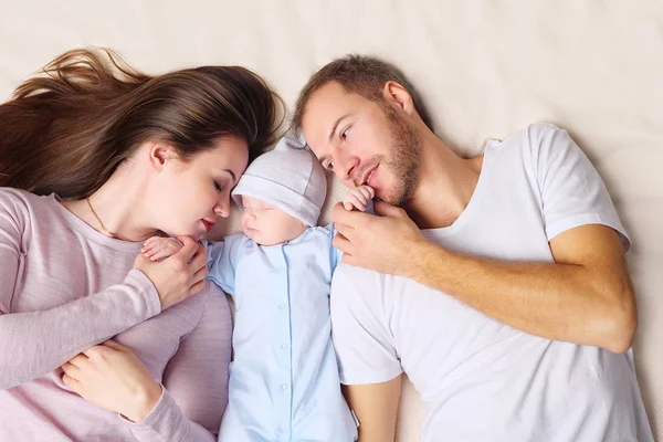 Parents couchés près du bébé endormi — Photo