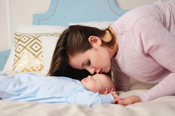 Matka, całuje w czoło dziecka podczas snu — Zdjęcie stockowe
