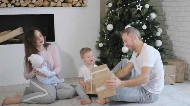 Familie openen de giften van Kerstmis in de buurt van boom — Stockvideo