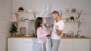 Evde mutfakta yemek yaparken şarkı ve dans eğlenceli genç Slowmotion neşeli çift var
