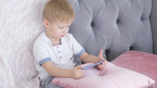 Αγόρι παιχνίδια smartphone στον καναπέ — Αρχείο Βίντεο