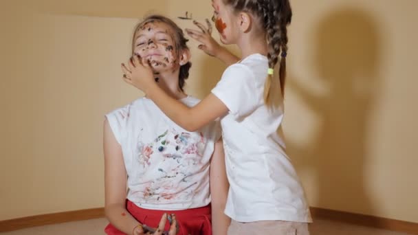 Playful girls coloring each other with paints