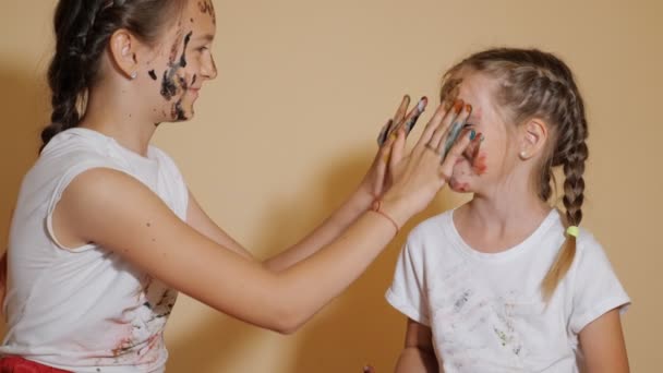 Chicas juguetonas para colorear entre sí con pinturas — Vídeos de Stock