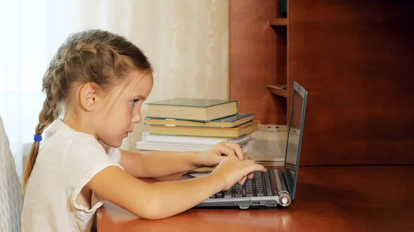 Kleines Mädchen benutzt Laptop am Schreibtisch — Stockfoto