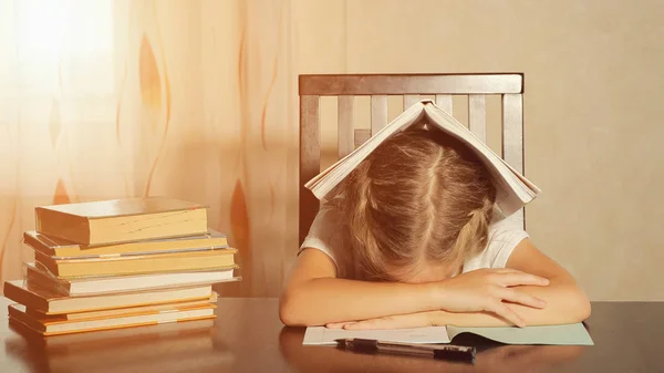 Aluna cansada com livros à mesa — Fotografia de Stock