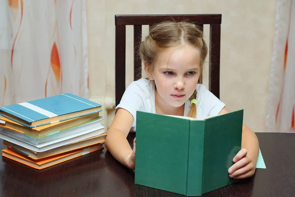 Menina estudando em livro de leitura de mesa — Fotografia de Stock