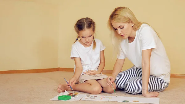 Мать с девушкой рисует на бумаге — стоковое фото