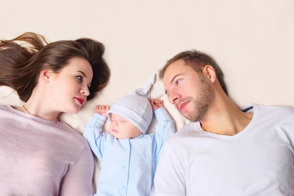 Parents couchés près du bébé endormi — Photo