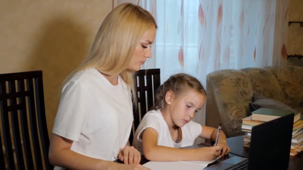 Женщина с маленькой девочкой делают домашнее задание вместе — стоковое видео
