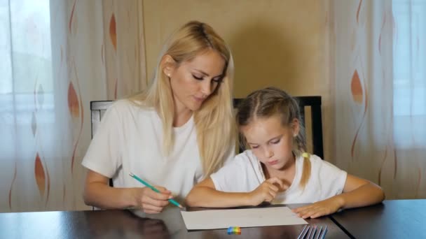 Жінка з маленькою дівчинкою малює на папері — стокове відео
