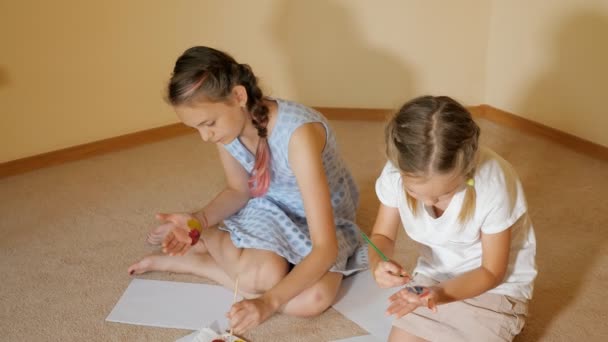 Niñas dibujo con acuarelas en papel y en las manos — Vídeo de stock