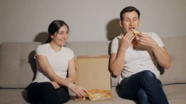 Pizza yiyen genç bir çift.