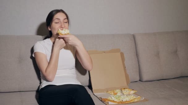 Menina feliz em comer pizza em casa — Vídeo de Stock