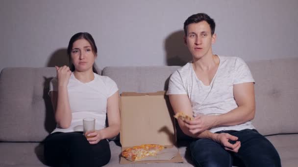 愉快的夫妇看电视, 当吃比萨 — 图库视频影像