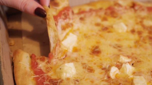 Очень сырный кусок пиццы в руке — стоковое видео