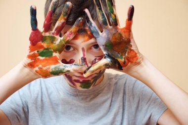 Çocuğun yüzünü ve ellerini boya ile portre