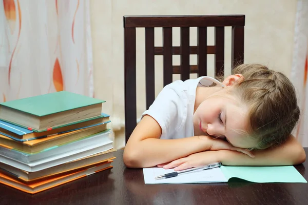 Aluna cansada com livros à mesa — Fotografia de Stock