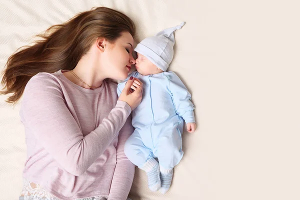 Młoda matka śpiące w pobliżu baby — Zdjęcie stockowe
