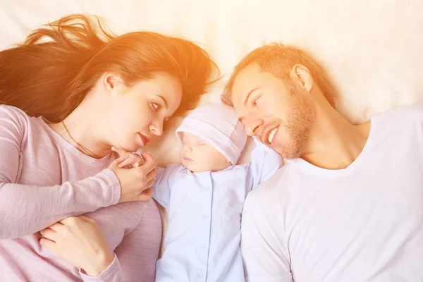 Parents couchés près du bébé endormi — Photo