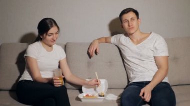 Bir gece evde olan ve Japonca yeme keyfini çekici genç çift yemek götürmek