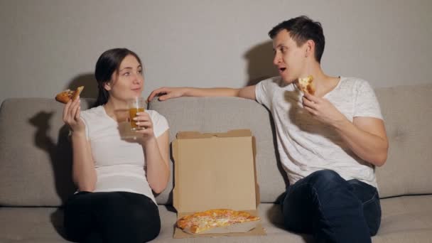 Молодая пара ест пиццу — стоковое видео