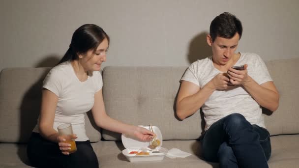Mujer aburrida mientras el hombre toma el juego en el teléfono móvil en la casa — Vídeos de Stock