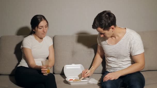 Atraente jovem casal ter uma noite em casa e desfrutar de comer japonês levar comida — Vídeo de Stock