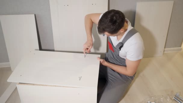 Jeune réparateur assemblant une nouvelle table à l'intérieur de la maison — Video