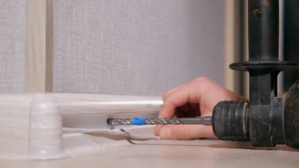 Crop man drilling holes in floor molding — Stock Footage Crop man drilling holes in floor molding Video Clip