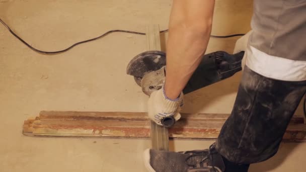 Чоловік ріже металеву дошку з пилкою — стокове відео
