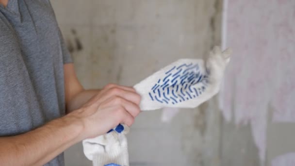 Рабочий, надевающий перчатки — стоковое видео