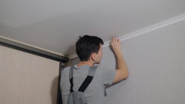 Человек применяет потолочное литье в комнате — стоковое видео