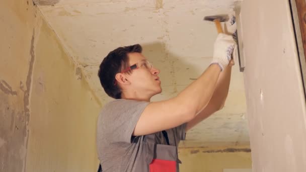 Hombre fijación tablón con clavos en la pared — Vídeo de stock