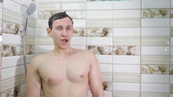 Naakte man met douche in de badkamer onder koud water — Stockvideo