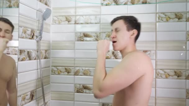 Svalnatý mladík bere sprchu. — Stock video