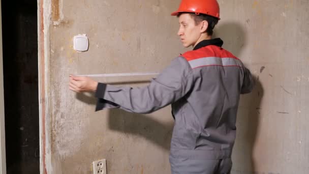 Hombre midiendo ancho de pared de hormigón — Vídeos de Stock