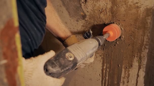 Рабочий с помощью молотка сверла на месте — стоковое видео