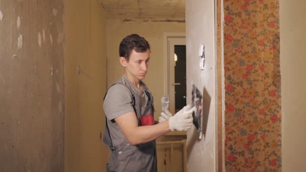 Man pleisterwerk muur in appartement — Stockvideo