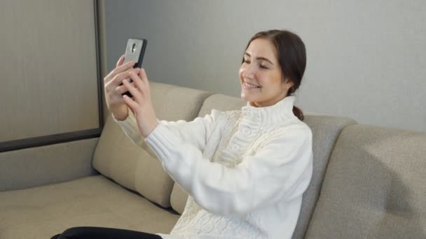 Νεαρό κορίτσι λήψη φωτογραφιών ή την πραγματοποίηση selfie στην κρεβατοκάμαρά της — Αρχείο Βίντεο