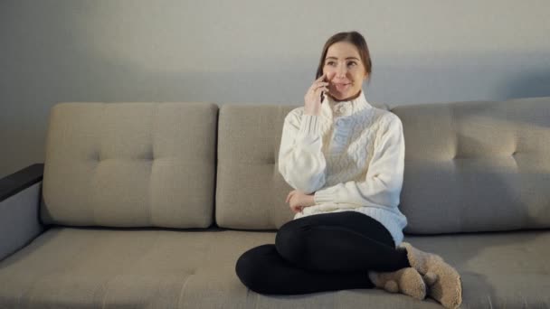 Lachende vrouw praten over de telefoon thuis — Stockvideo