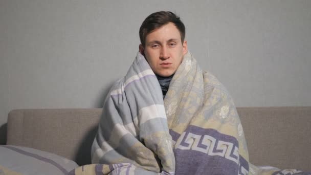 Больной, завернутый в теплое одеяло и дрожащий от холода — стоковое видео