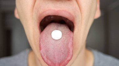 Adam alarak hap, tablet ilaç veya ilaç açık ağız ile dil üzerinde