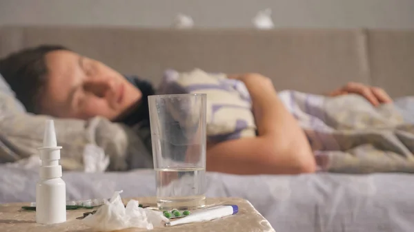 Лекарство и стакан воды рядом с больным парнем — стоковое фото